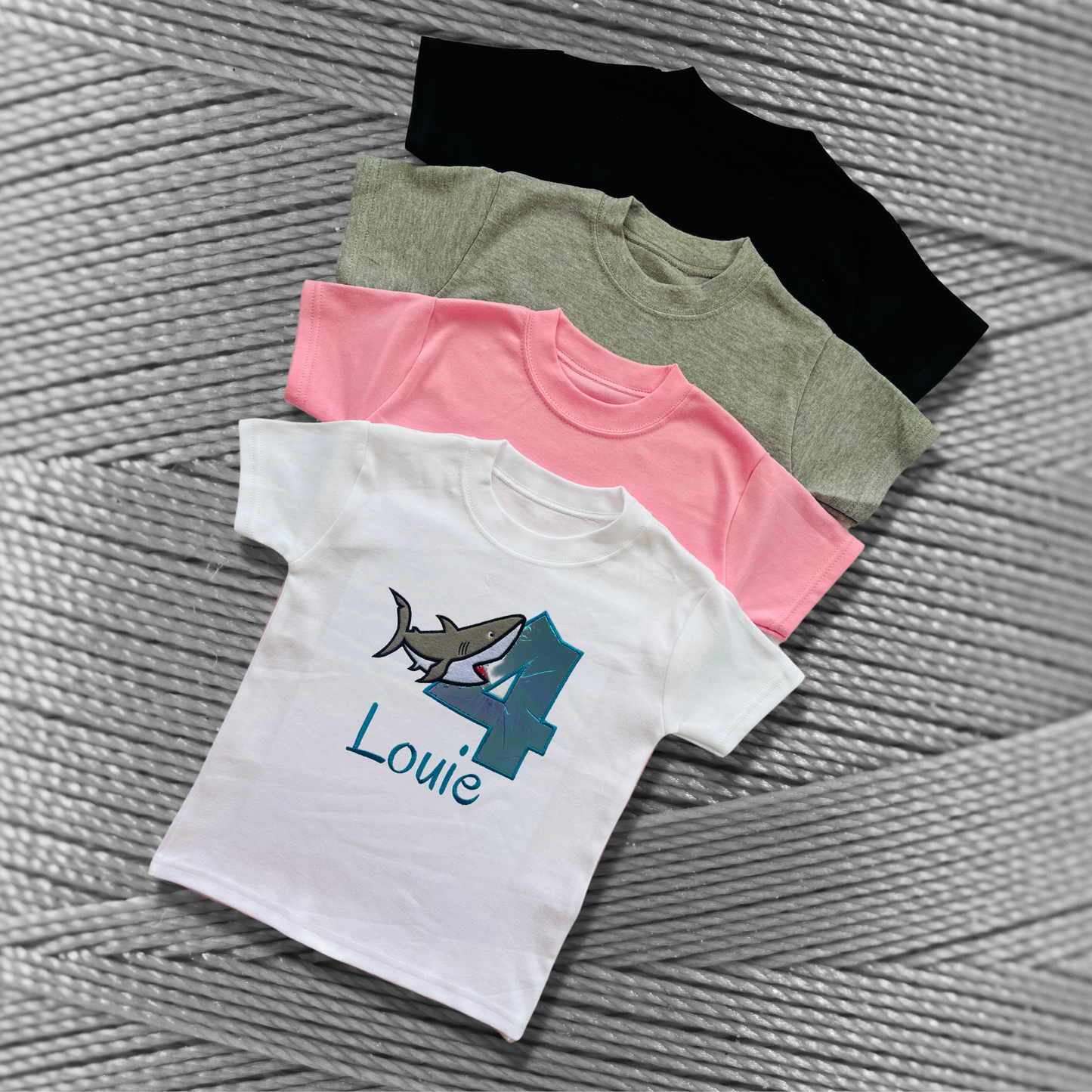 Childrens soft cotton t-shirt. Embroidered applique on the front with the birthday age, shark design and the childs name.