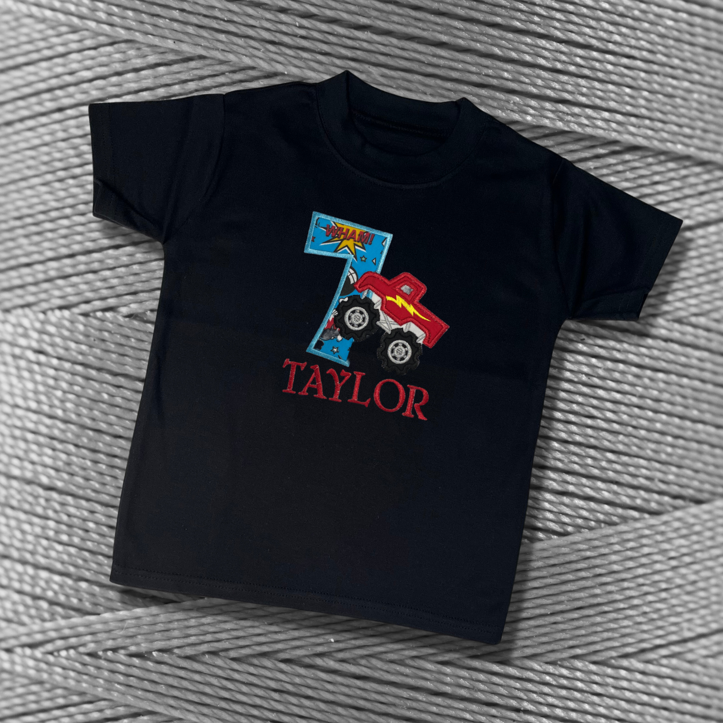 Childrens Black soft cotton t-shirt. Embroidered applique on the front with the birthday age, monster truck design and the childs name.