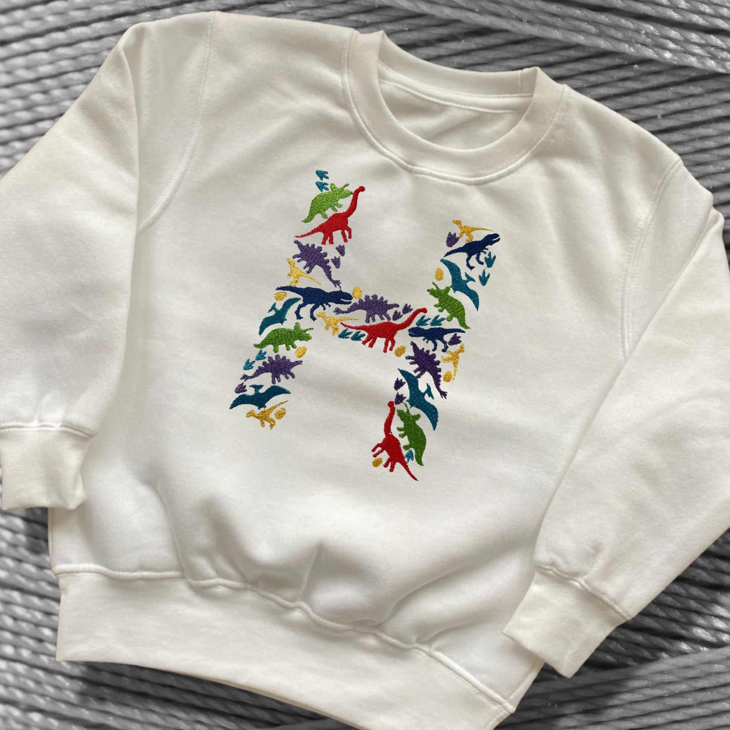 Personalised Embroidered Children's Dinosaur Top. Colourful Dinosaur's Make Up the Letter of the Alphabet. A Perfect Gift for Dinosaur Fans.