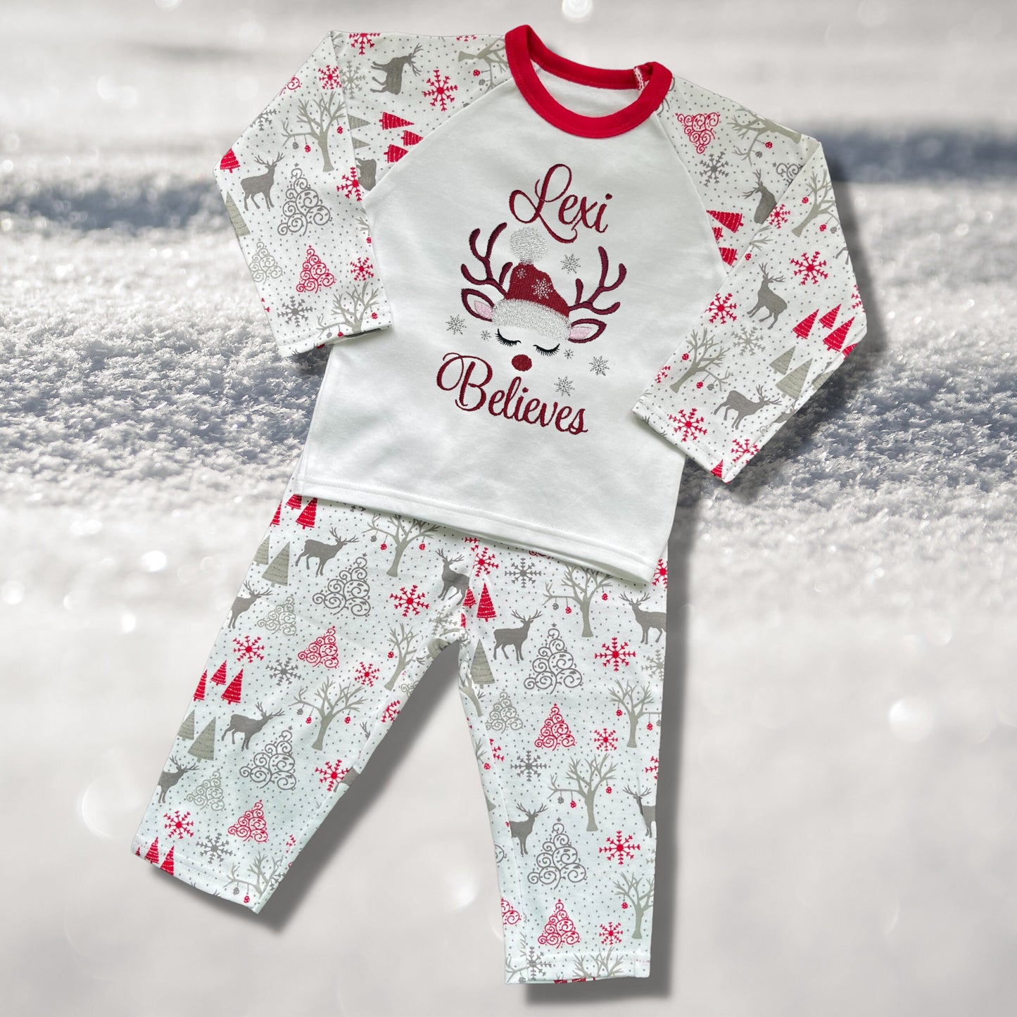 Personalised Embroidered Christmas Childrens Pyjamas and Rompersuits with a Gorgeous Winter Reindeer and the Words 'Believes' under the Name