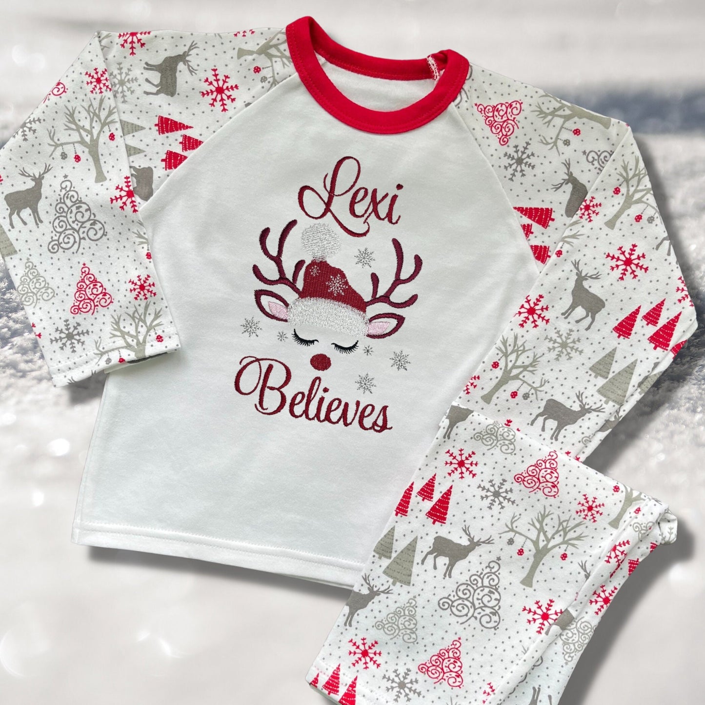 Personalised Embroidered Christmas Childrens Pyjamas and Rompersuits with a Gorgeous Winter Reindeer and the Words 'Believes' under the Name