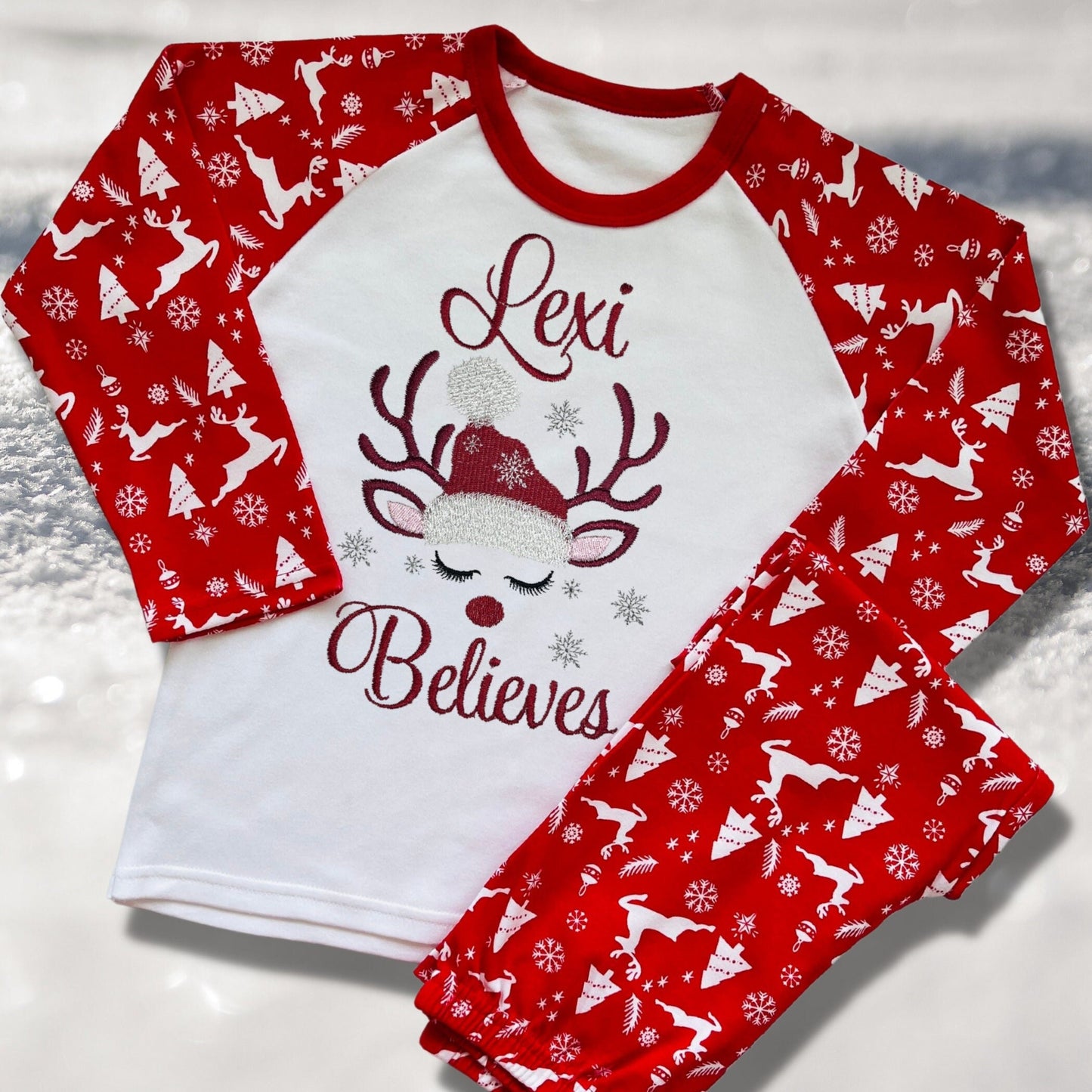 Personalised Embroidered Christmas Childrens Pyjamas and Rompersuits with a Gorgeous Winter Reindeer and the Words 'Believes' under the Name