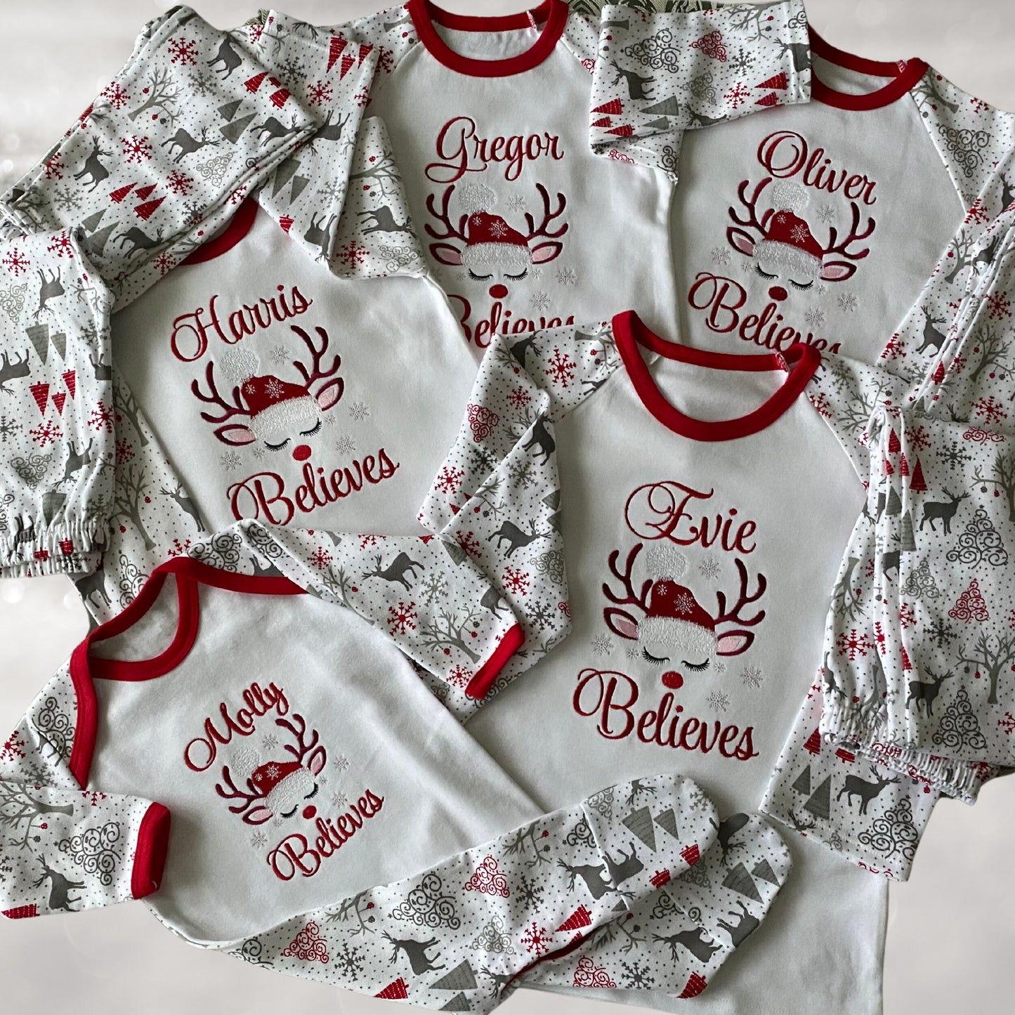 Personalised Embroidered Christmas Childrens Pyjamas and Rompersuits with a Gorgeous Winter Reindeer and the Words 'Believes' under the Name