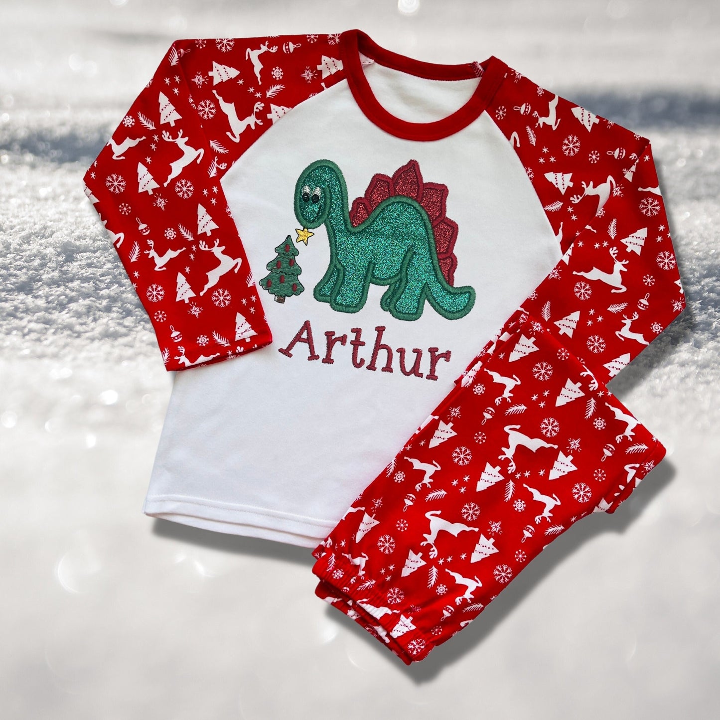 Personalised Embroidered Christmas Childrens Pyjamas and Rompersuits. Cute Dinosaur Putting a Star on his Tree. Finished with Child's Name
