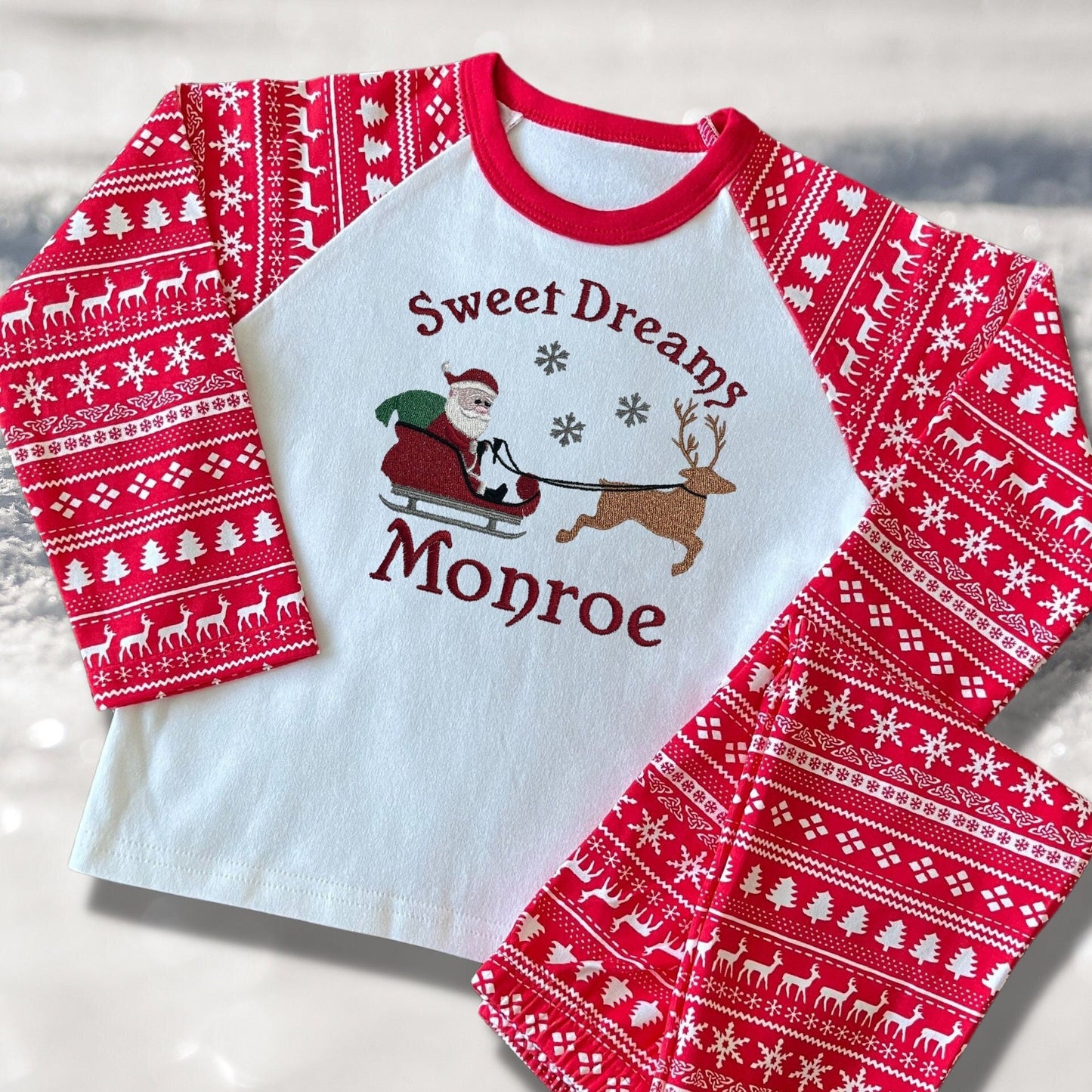Personalised Embroidered Christmas Childrens Pyjamas and Rompersuits with Santa, his Sleigh and a Reindeer. With the Words 'Sweet Dreams'.