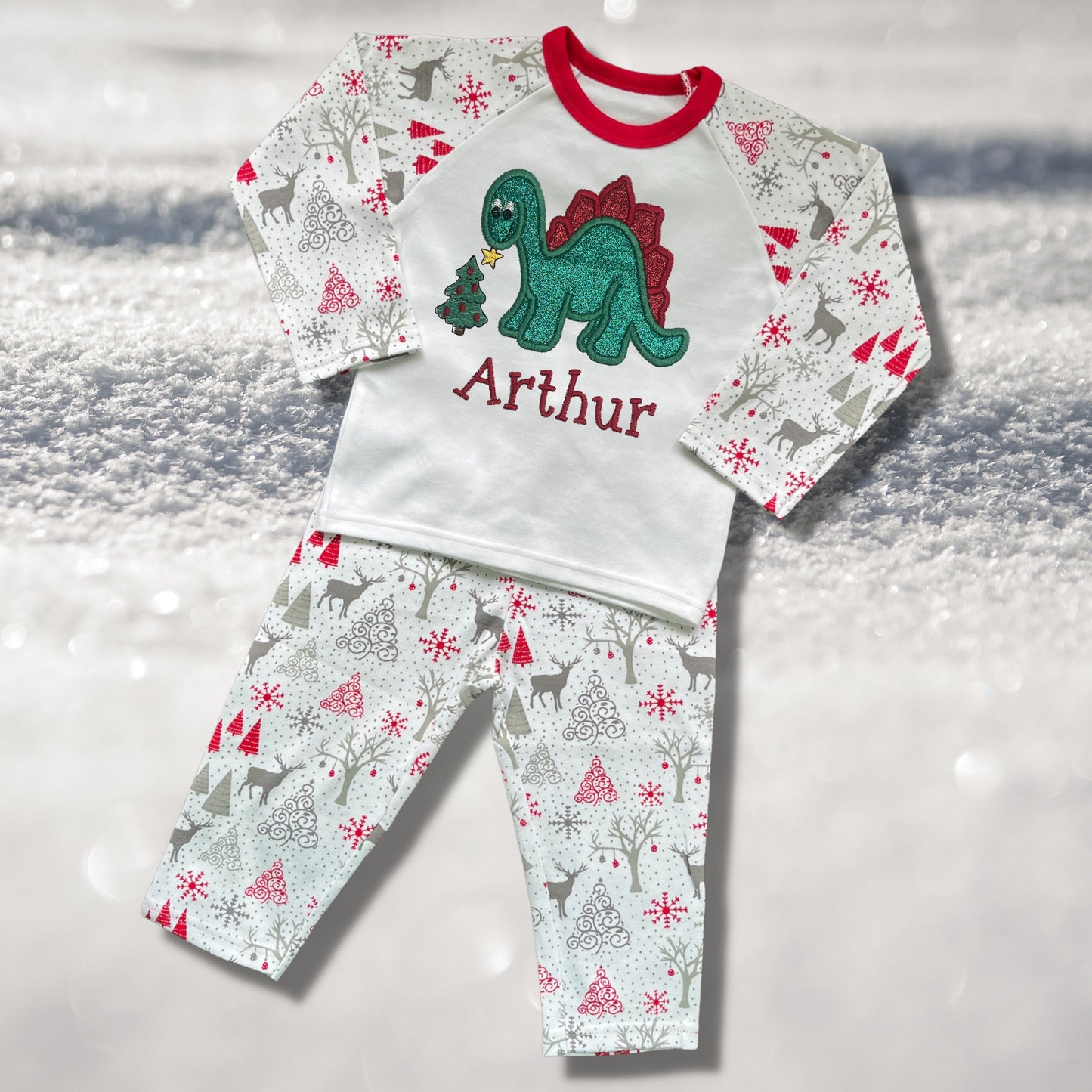 Personalised Embroidered Christmas Childrens Pyjamas and Rompersuits. Cute Dinosaur Putting a Star on his Tree. Finished with Child's Name
