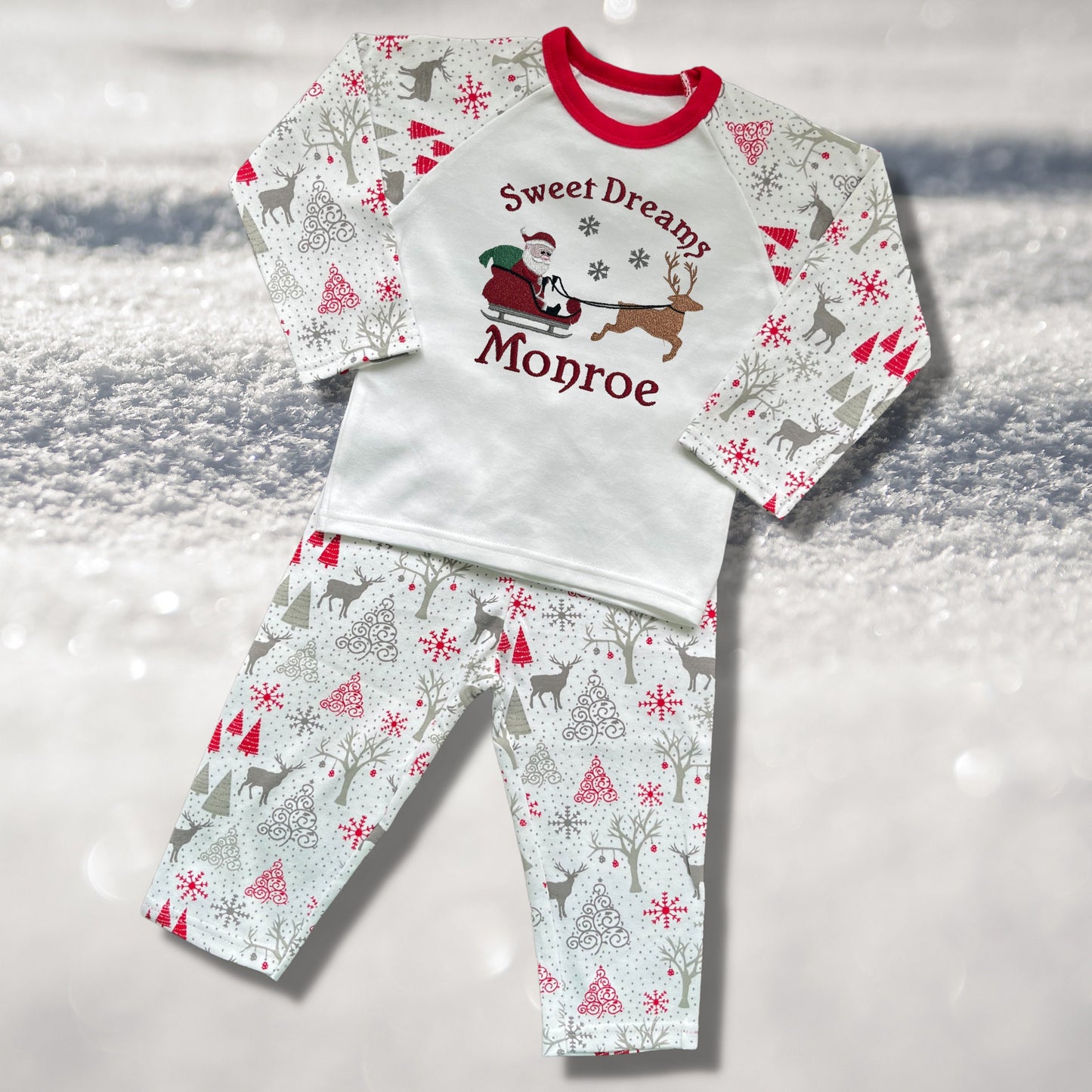 Personalised Embroidered Christmas Childrens Pyjamas and Rompersuits with Santa, his Sleigh and a Reindeer. With the Words 'Sweet Dreams'.