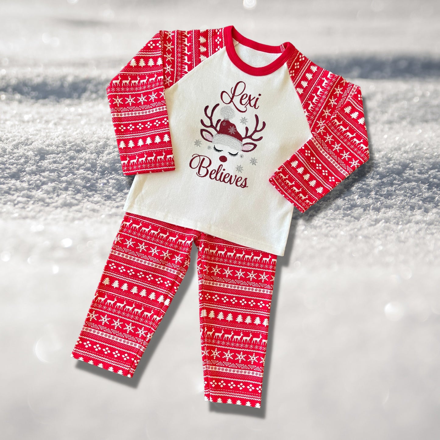 Personalised Embroidered Christmas Childrens Pyjamas and Rompersuits with a Gorgeous Winter Reindeer and the Words 'Believes' under the Name