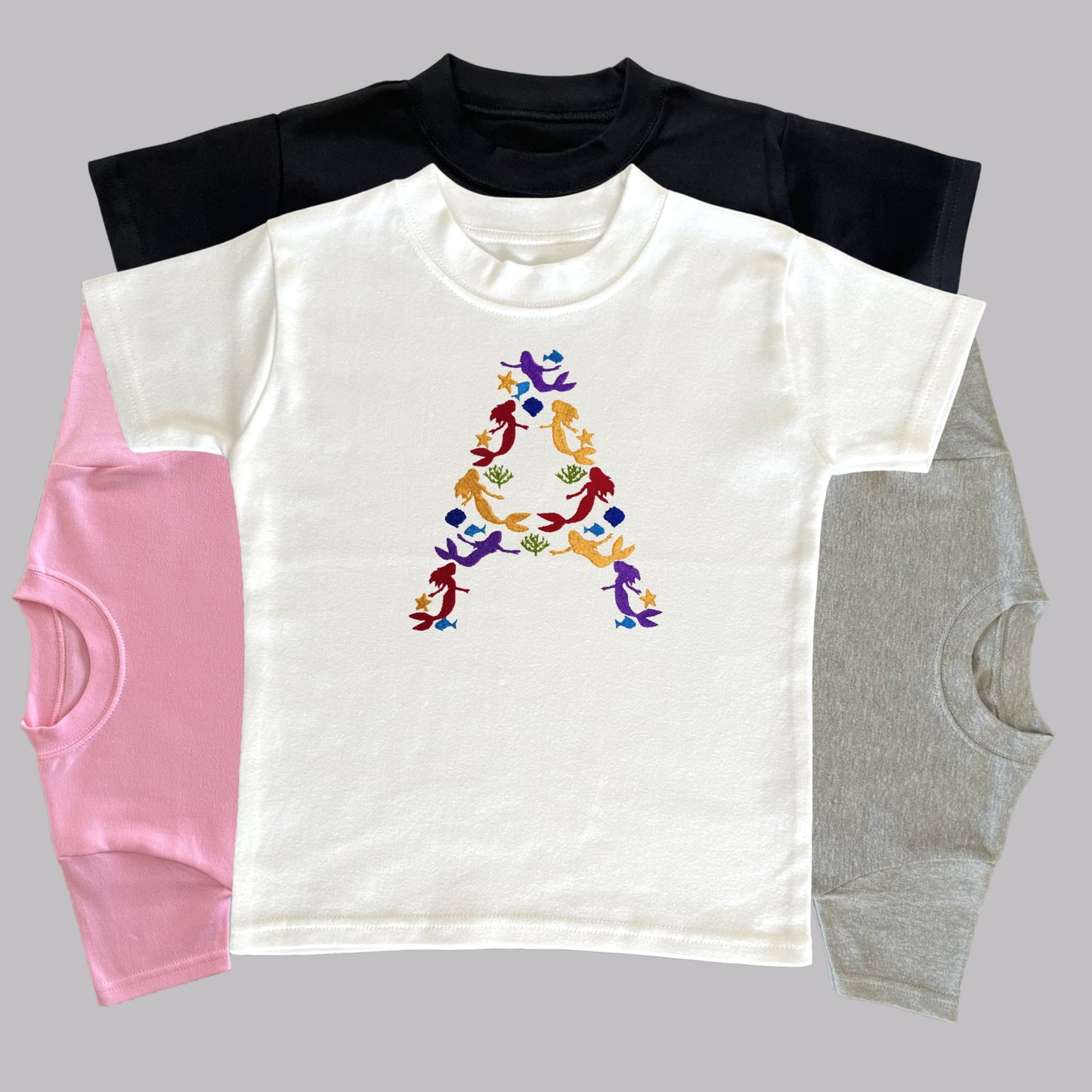 Children's Personalised Embroidered Top. Colourful Mermaids make up the Child's Initial. Perfect Gift for Children who Love Mermaids.