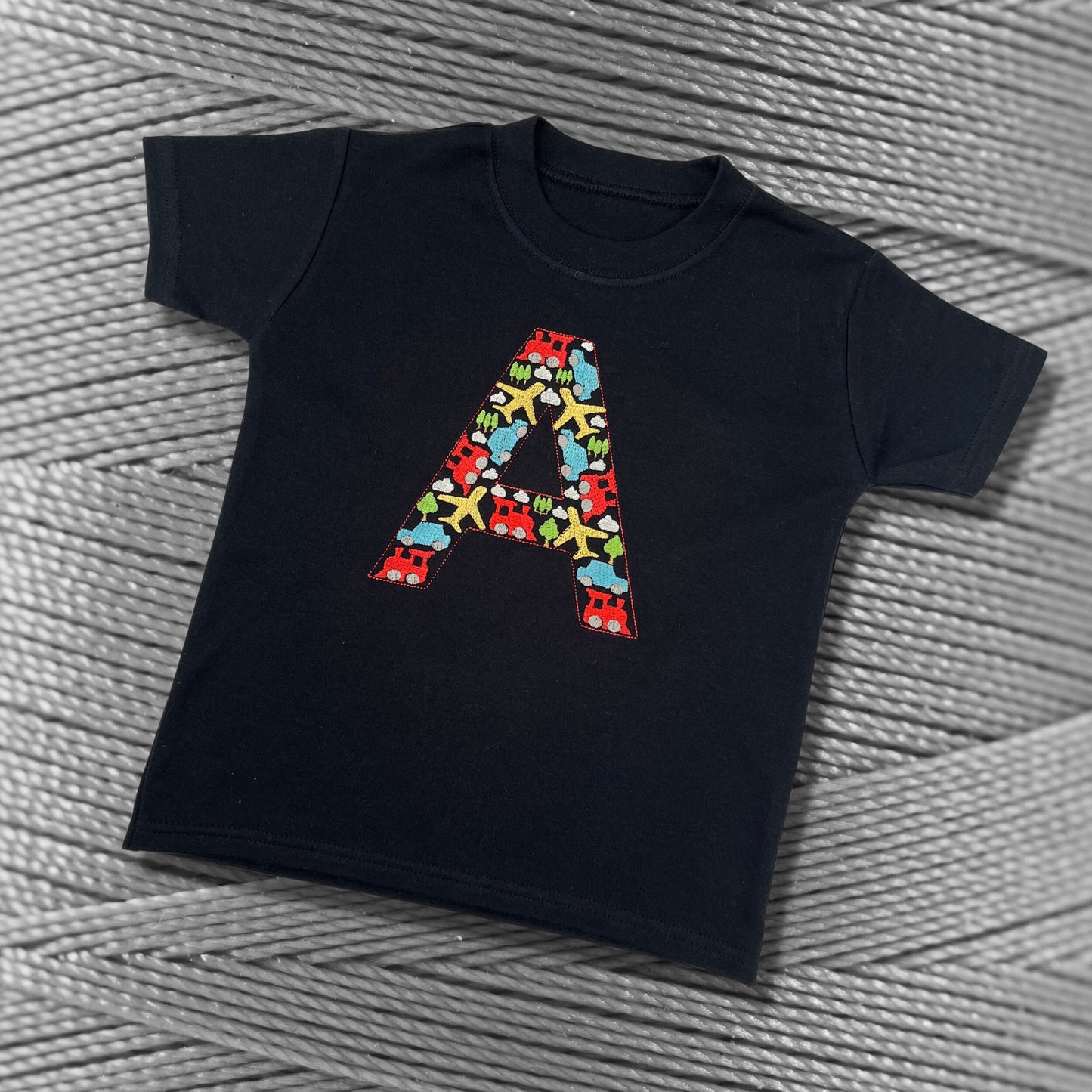 Personalised Embroidered Children's Top. Colourful Cars Trains and Planes Make Up the Letter. A Perfect Gift for Kids who Love Vehicles.