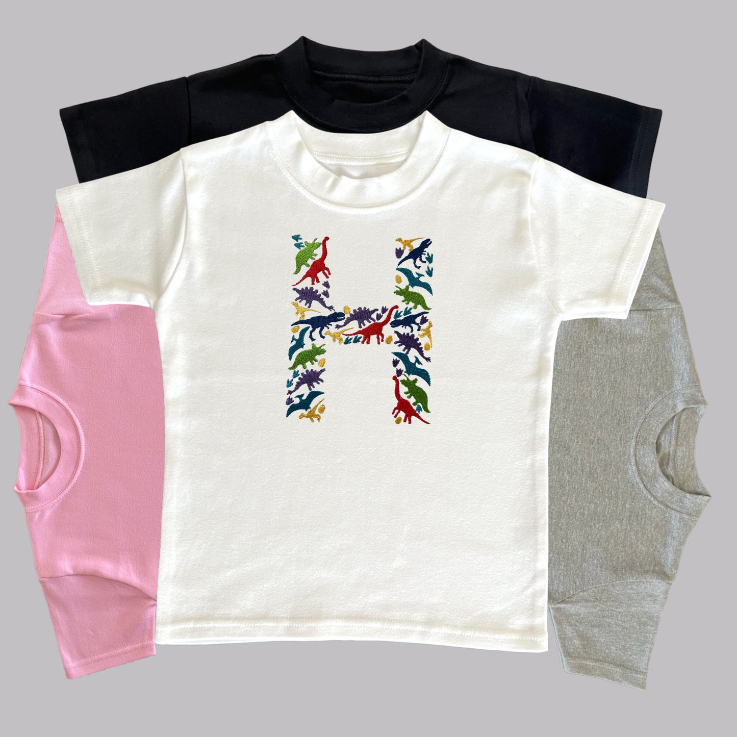 Personalised Embroidered Children's Dinosaur Top. Colourful Dinosaur's Make Up the Letter of the Alphabet. A Perfect Gift for Dinosaur Fans.