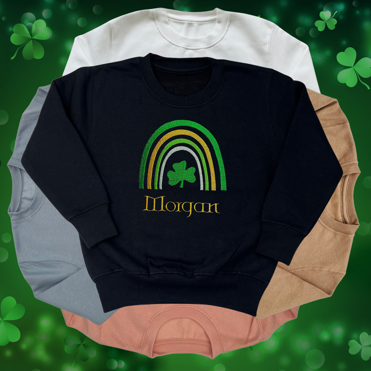 Black sweatshirt with rainbow and shamrock design using green and gold thread. With child's name under design in gold thread