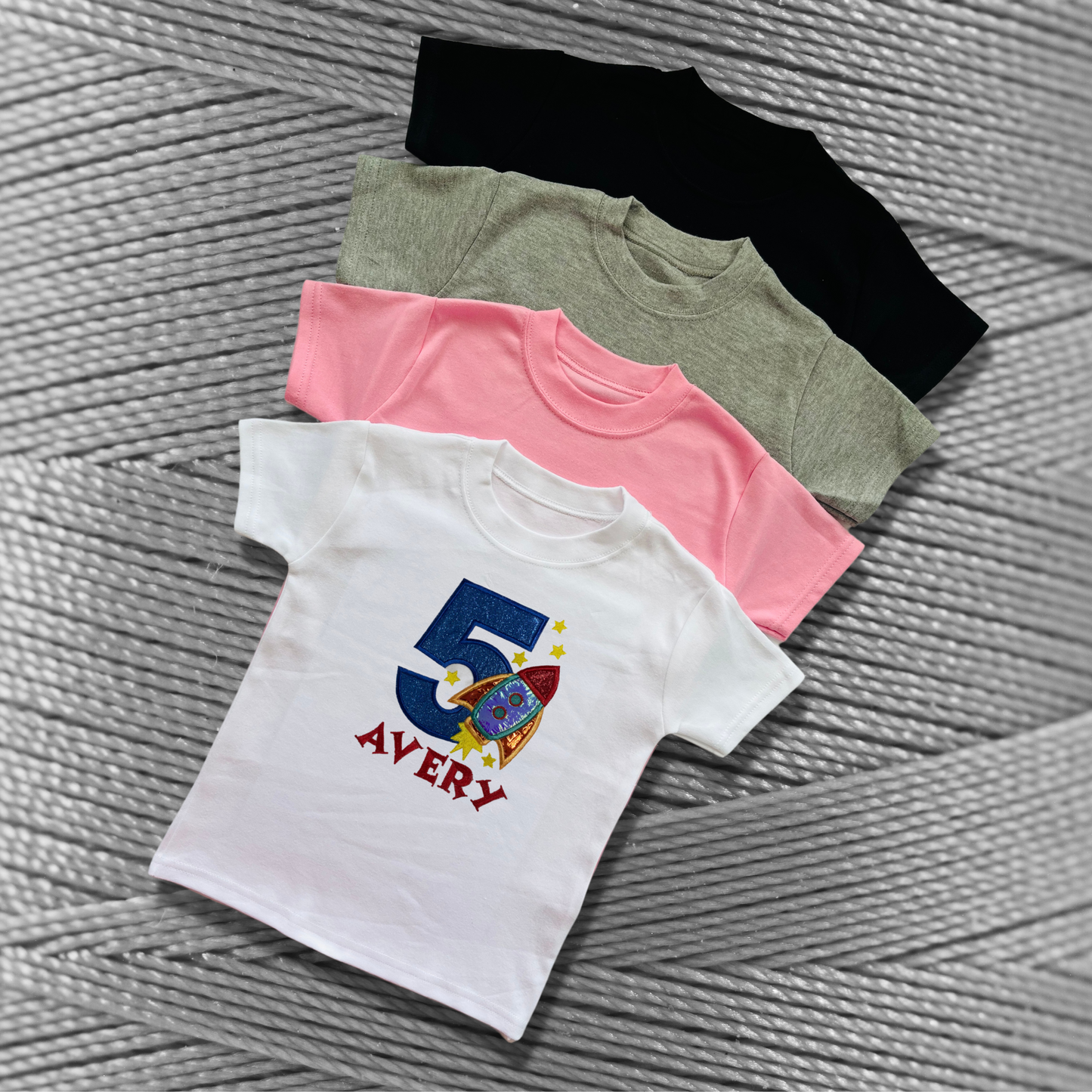 Childrens soft cotton t-shirt. Embroidered applique on the front with the birthday age, rocket design and the childs name.