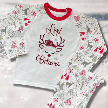 Personalised Embroidered Christmas Childrens Pyjamas and Rompersuits with a Gorgeous Winter Reindeer and the Words 'Believes' under the Name