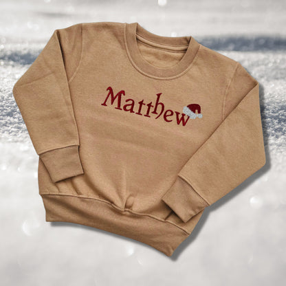 Personalised Embroidered Childrens Christmas Top. Cute Design with Name and Santa Hat. Perfect for the Christmas Season. Choice of Garment