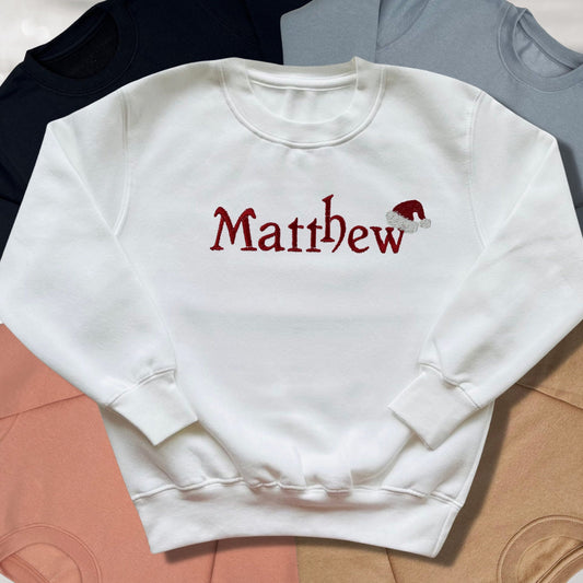 Personalised Embroidered Childrens Christmas Top. Cute Design with Name and Santa Hat. Perfect for the Christmas Season. Choice of Garment