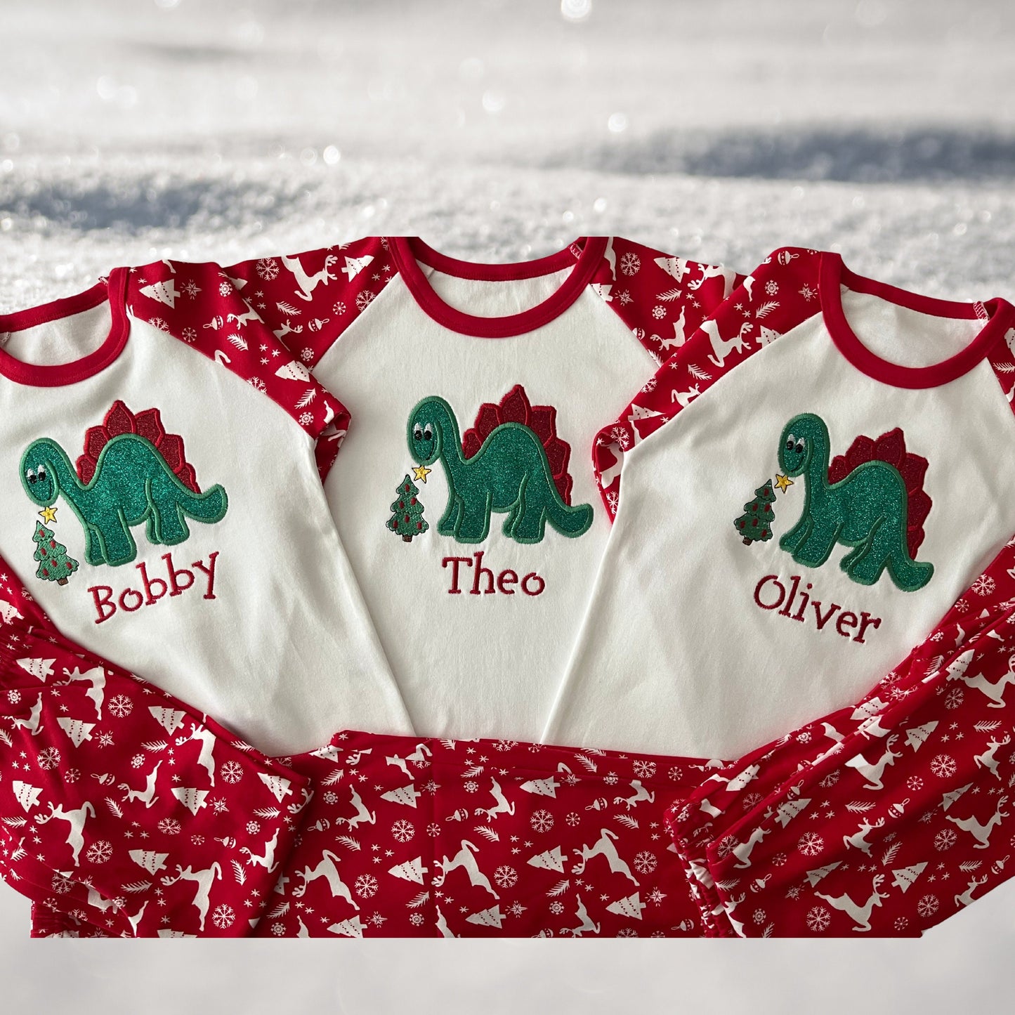 Personalised Embroidered Christmas Childrens Pyjamas and Rompersuits. Cute Dinosaur Putting a Star on his Tree. Finished with Child's Name