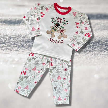 Personalised Embroidered Christmas Childrens Pyjamas and Rompersuits with the Cutest Gingerbread Girl and Boy Holding Hands Under a Garland.