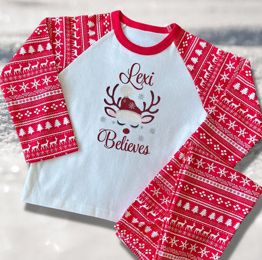 Personalised Embroidered Christmas Childrens Pyjamas and Rompersuits with a Gorgeous Winter Reindeer and the Words 'Believes' under the Name