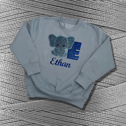 Children's Personalised Embroidered Top With a Cute Elephant Design. A Beautiful Design Using Glittery Blues with Child's Name and Initial