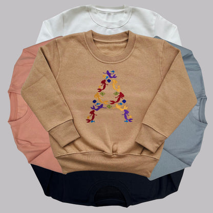 Children's Personalised Embroidered Top. Colourful Mermaids make up the Child's Initial. Perfect Gift for Children who Love Mermaids.